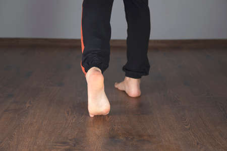 young woman walking barefoot in the house の写真素材