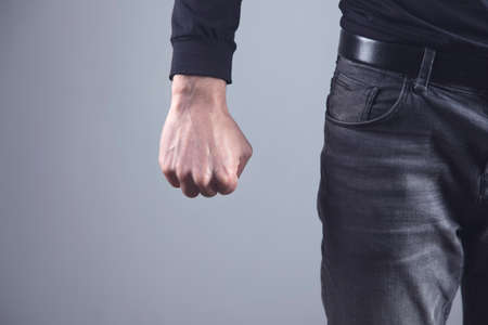 angry man fist on grey background