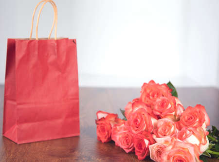 shopping bag and roses  on the tableの写真素材
