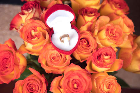 roses and ring on the table background