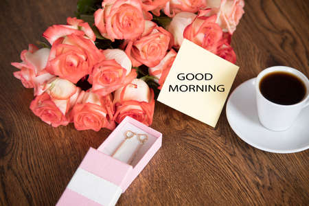 roses and coffee with good morning text on table