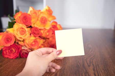 woman hand paper and roses on the tableの写真素材