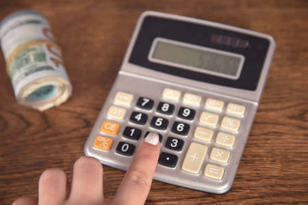 woman hand calculator and dollar on tableの写真素材