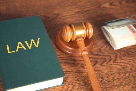 judge and book with money on tableの写真素材