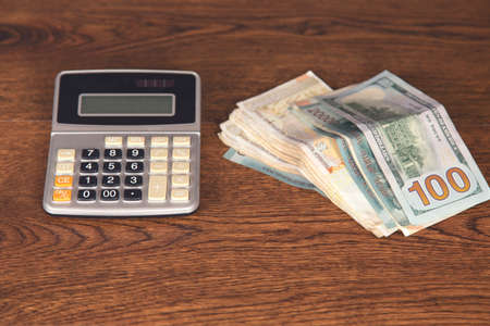 calculator and money on the wooden table