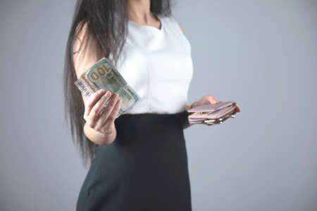 woman hand money and wallet on grey backgroundの写真素材
