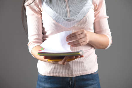 woman hand pen and notepad on gray background
