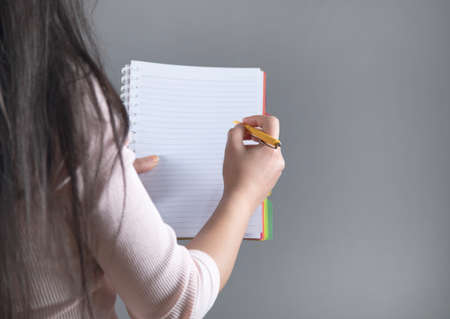 woman hand pen and notepad on gray background