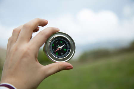 woman hand holding compass in nature backgroundの写真素材