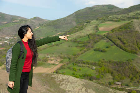young woman show in green grass mountain
