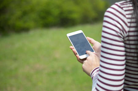 woman hand smart phone in nature backgroundの写真素材
