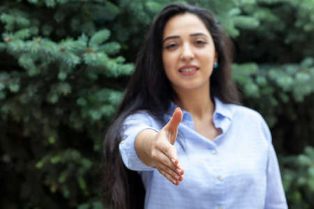 woman greet by hand in the street background