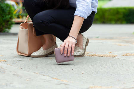 woman and a wallet on the ground in streetの写真素材