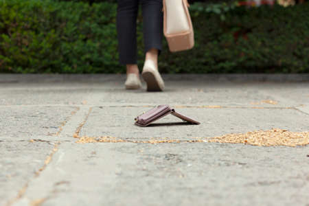 woman and a wallet on the ground in street