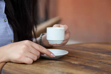 woman hand cup of coffee in cafe