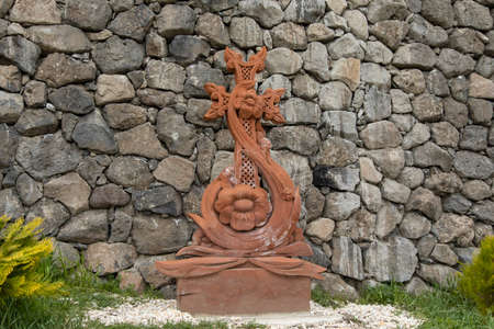 Cross stone in the green grass mountain background