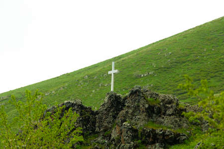 stone cross in the green mountain backgroundの写真素材
