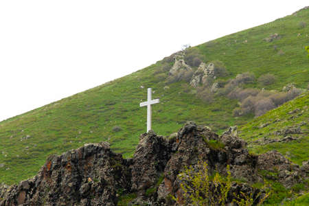 stone cross in the green mountain background