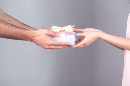 woman and man hand gift box on gray backgroundの写真素材