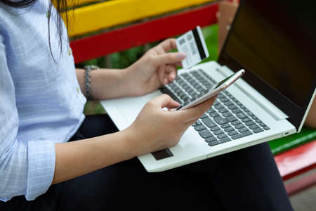 woman hand card and phone with computer in street