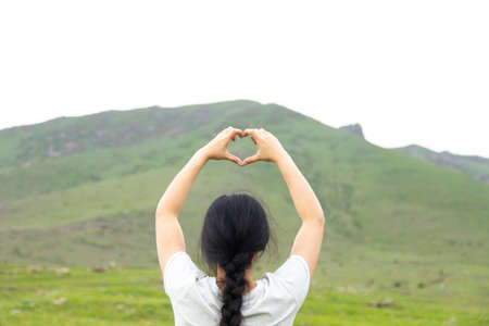 woman hand heart sign in mountain backgroundの写真素材