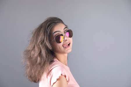 happy woman hand sunglasses on gray background
