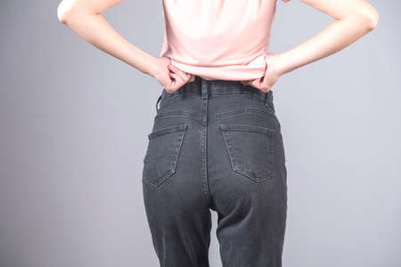 sexy woman in jeans on gray background