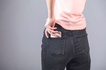 phone on woman jeans pocket on gray backgroundの写真素材