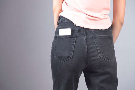 phone on woman jeans pocket on gray backgroundの写真素材