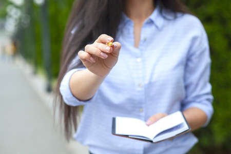 woman hand pen and notepad in the streetの写真素材