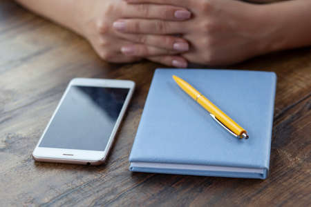 woman hand phone and notepad in cafeの写真素材