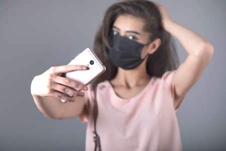 woman face mask and selfie on gray background