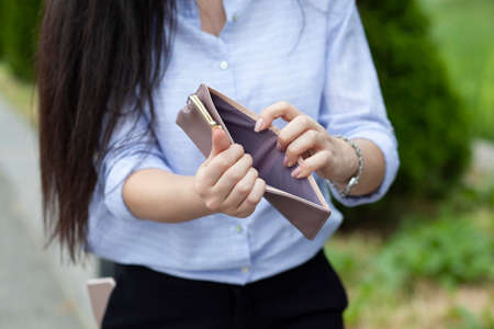 Woman holding empty wallet in the street