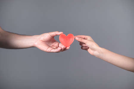 woman and man hand red heart on gray background
