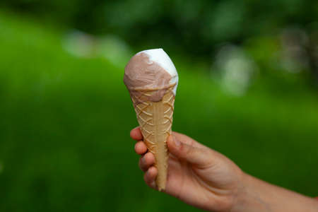 girl hand ice cream on green background