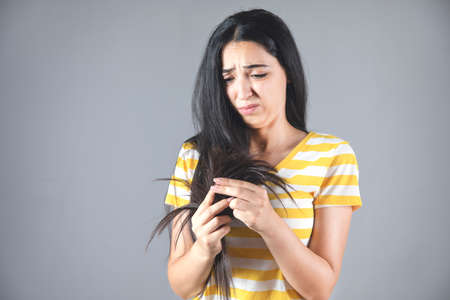 young sad woman hand black damaged hairの写真素材