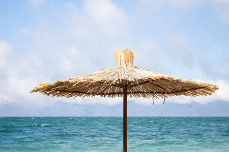 straw umbrella on the sea beach background