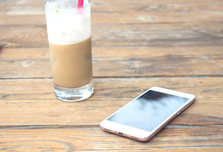 coffee and phone on the wooden tableの写真素材
