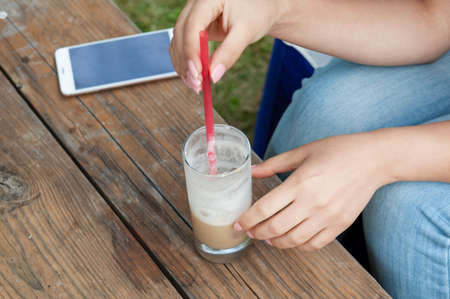 woman hand coffee and phone in street cafe