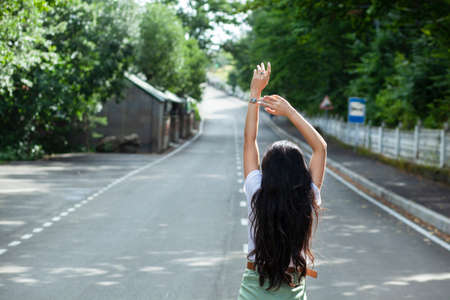 happy woman in the asphalt road backgroundの写真素材