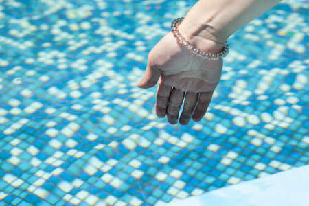 young woman hand in the pool waterの写真素材