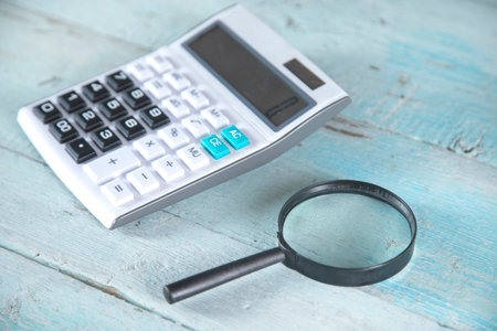 calculator and magnifier on the wooden table