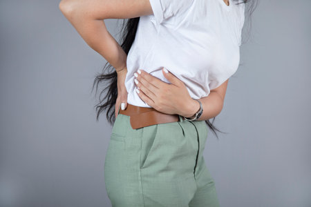 young woman hand in ache back