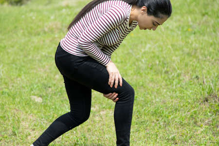 woman hand in ache feet in nature background