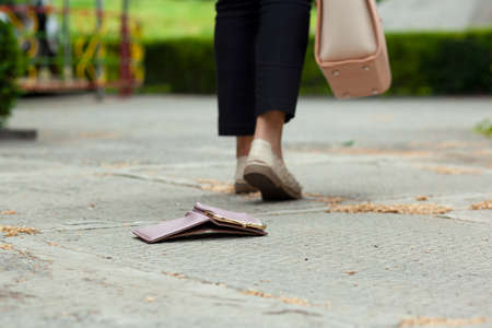 woman and a wallet on the ground in streetの写真素材