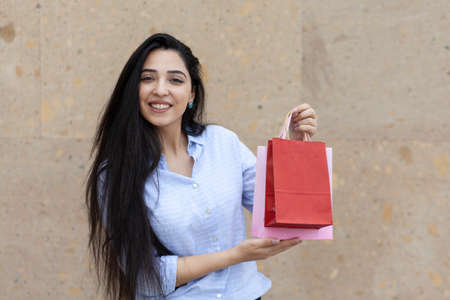 happy woman hand shopping bags in street