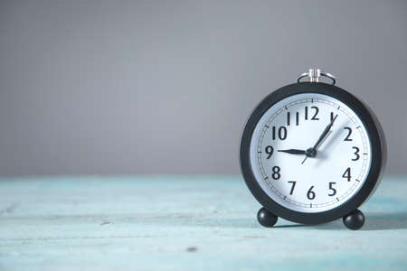 clock on the blue table and gray backgroundの写真素材
