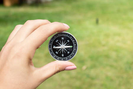 woman holding compass in green nature