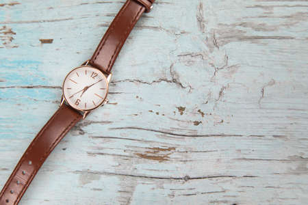 brown watch for woman on wooden table