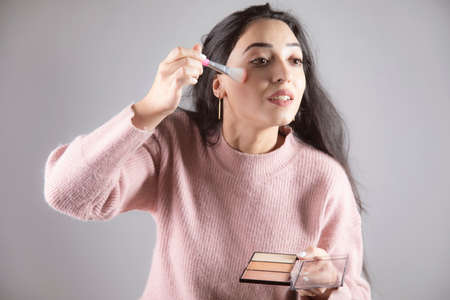 young woman holding brush and highlighterの写真素材